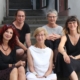 Fünf Frauen sitzen lächelnd auf einer Treppe